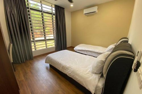 a bedroom with two beds and a window with a windowscription at Maxxim Rainforest Retreat - Rawang in Rawang