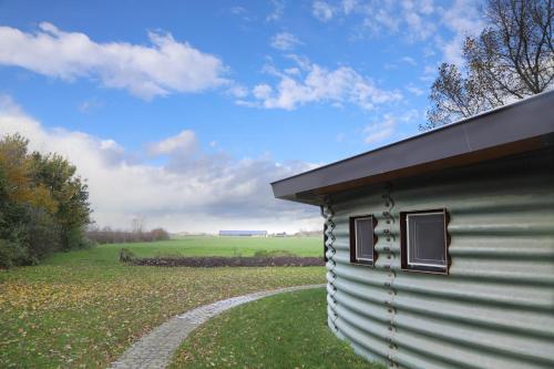 a shed with a path next to a field at Silo 161 in Ruinerwold