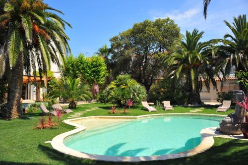 - une piscine dans une cour avec des palmiers dans l'établissement Villa Valflor chambres d'hôtes et appartements, à Marseille