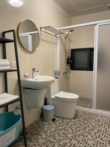a bathroom with a sink and a toilet and a mirror at MiShi 85 Guest House in Lugang