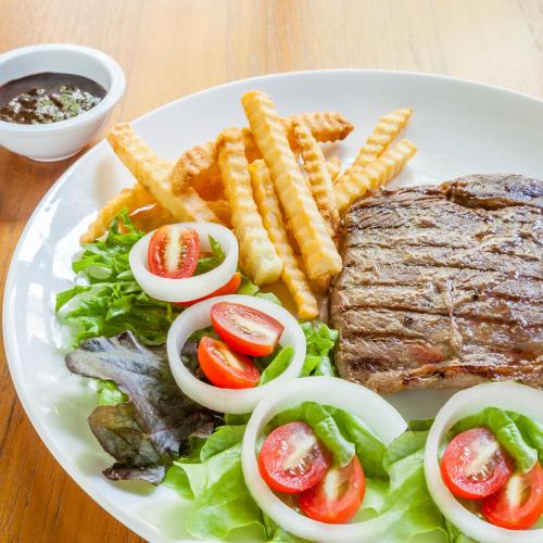 a plate of food with steak and french fries at At Hua Lamphong Hotel in Bangkok