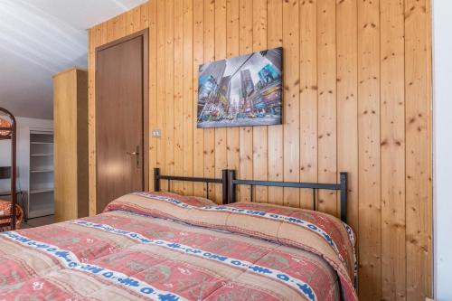 a bedroom with a bed and a wooden wall at Casa Vacanza Zambotti in Vermiglio