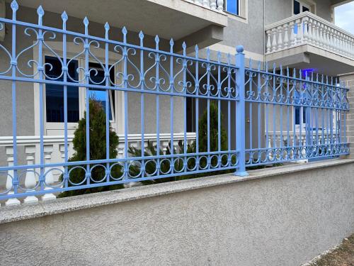 a blue fence on the side of a building at Doci Seven Hotel in Velipojë