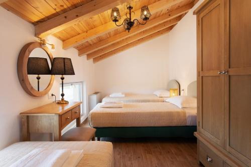 a bedroom with two beds and a mirror at Aneli Luxury Villas - Villa Semeli in Zakynthos Town