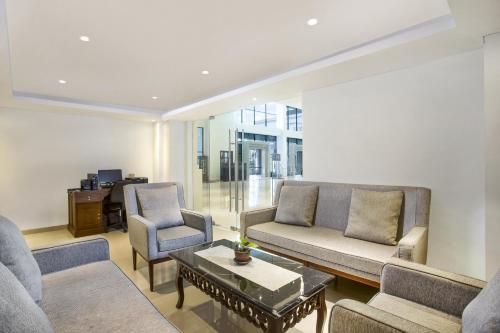 a living room with a couch and two chairs and a table at Grand Rohan Jogja in Yogyakarta