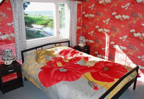 a bedroom with a bed with a red wall at Karineeme Holiday House in Mahu