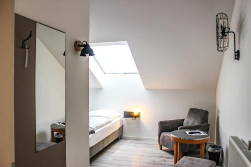 a room with a bed and a chair and a mirror at PRIMA Inn Unterkunft direkt über der "Bar am Minimax" in Neuruppin