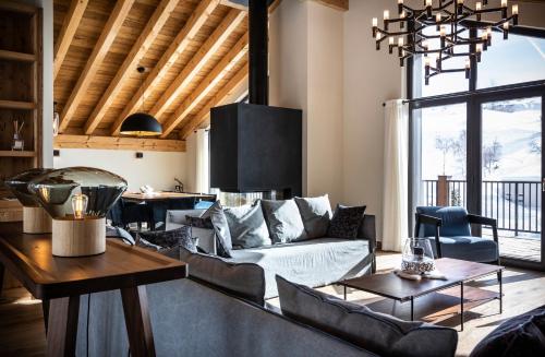 a living room with a couch and a table at Chalet le Blue Moon in L'Alpe-d'Huez
