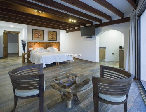 1 dormitorio con 1 cama, mesa y sillas en Gran Casa Con Pisina Privada Gimnasio Y Ping Pong, en Sant Mateu d’Albarca