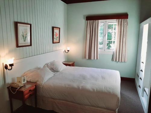a bedroom with a white bed and a window at Quinta Da Penha De Franca in Funchal