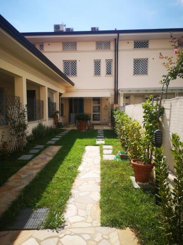 a courtyard of a house with grass and plants at CB House Tuscany in Pietrasanta
