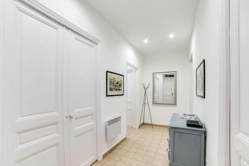 ニースにあるL'Écrin Blanc Niçois - Welkeysの白い壁の廊下、テレビ付きのドア