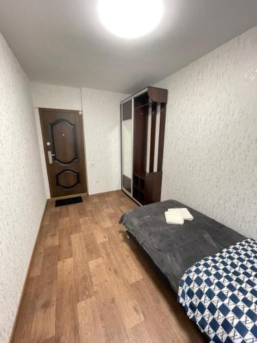 um pequeno quarto com uma cama e um espelho em Апартаменты Проспект Победы 101 em Chernihiv