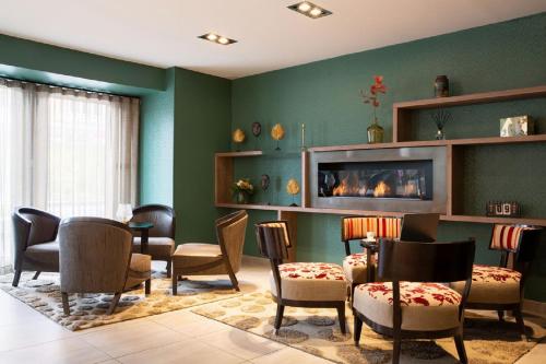 a waiting room with chairs and a fireplace at Best Western Plus Hôtel Belfort Centre Gare in Belfort