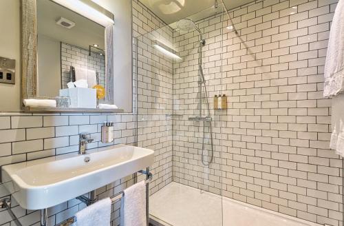 a white bathroom with a sink and a shower at The Wellington Arms in Heckfield