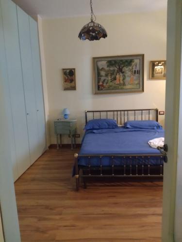 Schlafzimmer mit einem Bett mit blauer Tagesdecke in der Unterkunft Susy in San Sebastiano al Vesuvio