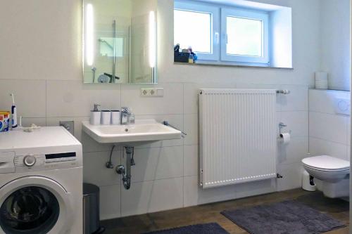 een badkamer met een wasmachine en een wastafel bij Ferienwohnung AusZeit in Bad Neustadt an der Saale