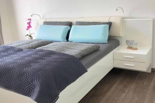a bed with two blue pillows on top of it at Ferienwohnung AusZeit in Bad Neustadt an der Saale