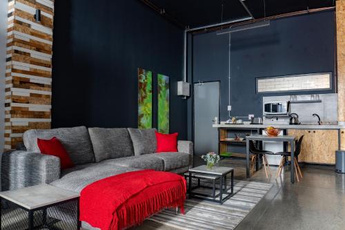 een woonkamer met een grijze bank en rode kussens bij Lilian Lofts Hotel & Spa in Johannesburg
