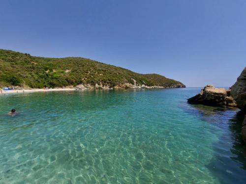 a person swimming in the water near a beach at Seagulls - Within walking distance from sea! in Petriaí