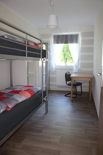 Gästewohnung in Niesky في Niesky: غرفة نوم بسريرين بطابقين وطاولة