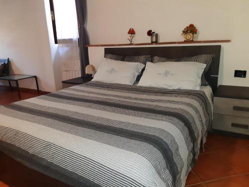 a bedroom with a large bed with two pillows at La casa in giardino in Volterra