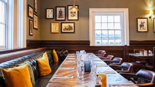 a dining room with a long table and chairs at The Wellington Arms - Basingstoke-Reading in Heckfield