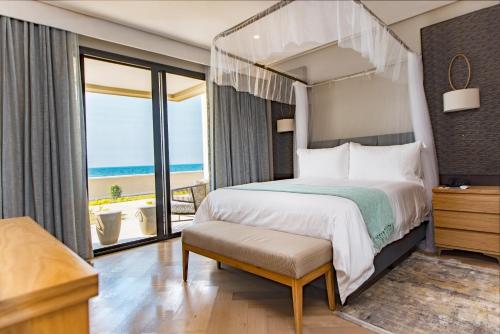 a bedroom with a bed and a view of the ocean at Sunbird Waterfront in Salima