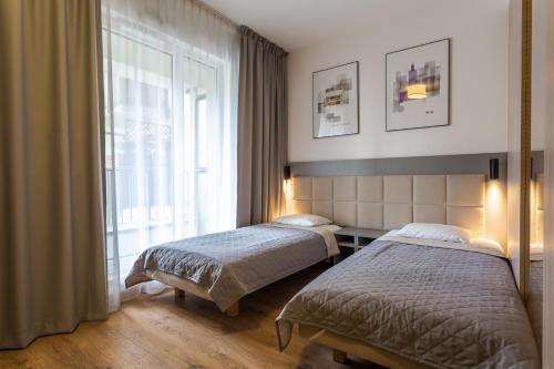 a bedroom with two beds and a window at RentPlanet - Apartamenty Wolska in Warsaw