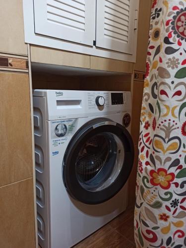 lavadora en una habitación con cortina en Casa Rural Abril, en Setenil