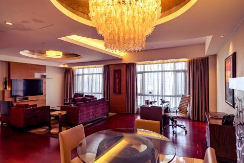 a hotel room with a chandelier and a living room at Swissôtel Grand Shanghai - Stroll down West Nanjing Road and soak in downtown Shanghai vibrancy in Shanghai
