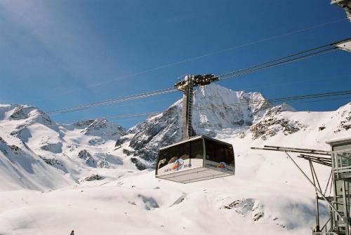 a ski lift in front of a snow covered mountain at Alpina Residence in Solda
