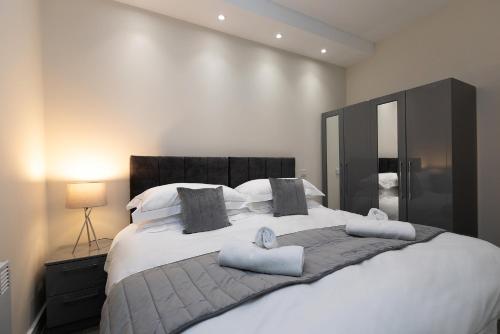 a bedroom with a large white bed with pillows at Pembroke Self Catering Apartments in Pembroke
