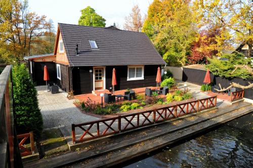 a house by the water with a bridge at Hotelanlage Starick in Lübbenau