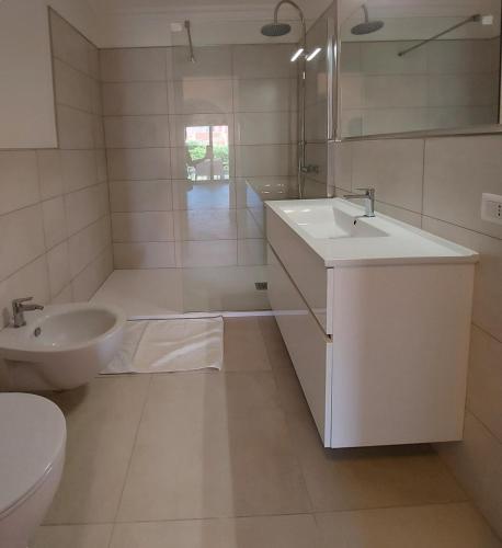 a white bathroom with a sink and a toilet at Villa Iris in Stintino