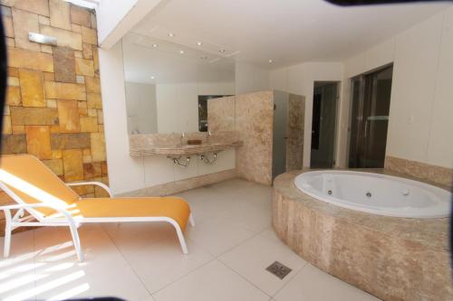 baño grande con bañera y lavamanos en Raru's Motel Litoral Norte (Adult Only), en Natal