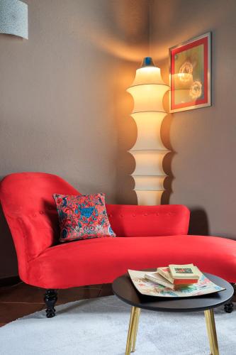 a red couch in a living room with a lamp at Antica Casa Balsari in Borgo Ticino