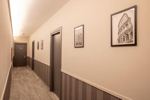 a hallway with framed pictures on the wall and a hallway with a hallway at Sophie Terrace Hotel in Rome