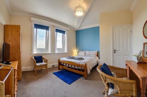 a bedroom with a bed and two chairs and a television at The Whitby Prospect in Whitby
