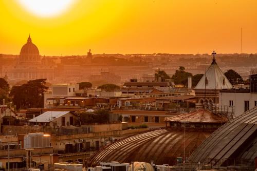 a city skyline with the sun setting in the background at Sophie Terrace Hotel in Rome