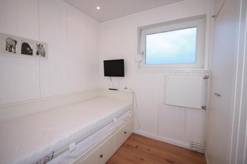 a white room with a white couch and a window at Ferienhaus am Ostseestrand in Großenbrode