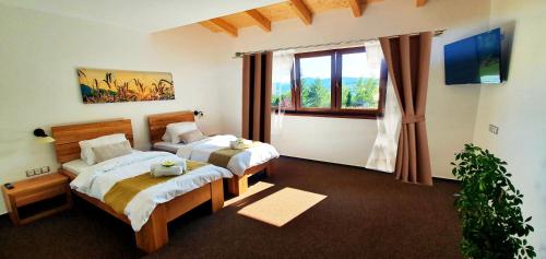 a hotel room with two beds and a window at Hotel Farma Vysoká in Chrastava