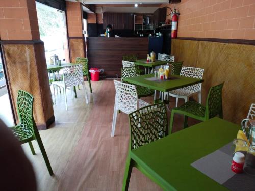 a empty restaurant with green tables and chairs at Hotel Himalaya Residency kanchenjunga view in Darjeeling