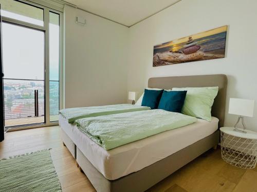 1 dormitorio con cama y ventana grande en TrIIIple Level 20 - Sonnenwohnen Apartment mit Parkplatz und fantastischem Ausblick en Viena