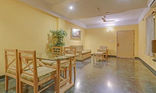 a living room with a table and chairs at Treebo Komfort Suites, 3 Km From Mysore Palace in Mysore