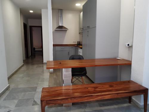 drewniany stół i ławka w pokoju w obiekcie Centro Histórico con Balcón 2 Bedrooms w Maladze