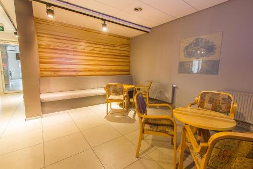 a waiting room with a table and chairs at Hotel Platan in Ostrów Wielkopolski