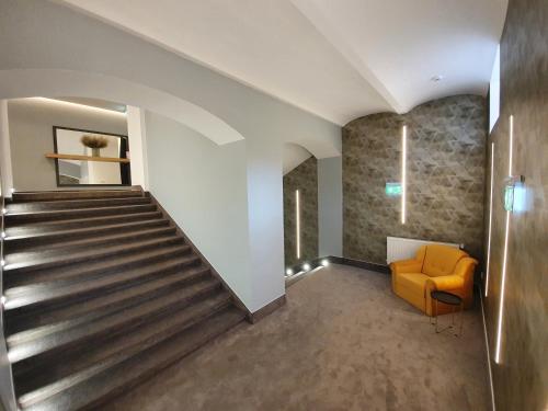 a staircase in a building with a yellow chair at JOYME Hotel in Sibiu