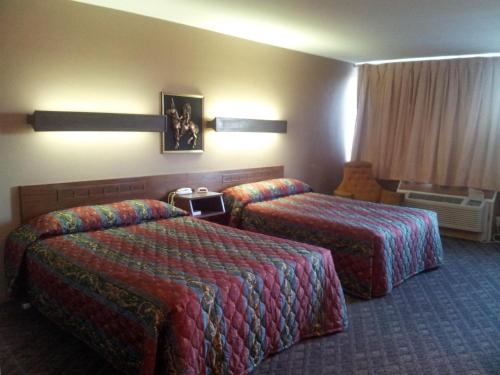 Habitación de hotel con 2 camas y ventana en Indian Head Motel, en Winamac