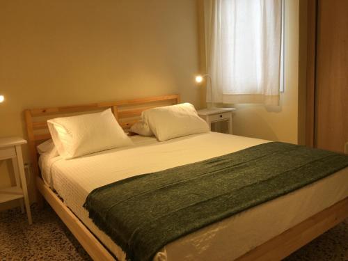una camera da letto con un letto con due cuscini e una finestra di Apartamento Los Laureles - El Fraile ad Arona